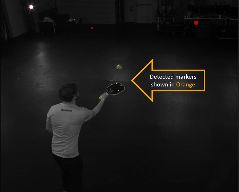 An image taken from an OptiTrack camera in Duplex mode, with an arrow-shaped text box pointing to the orange-colored markers visible in the shot. 