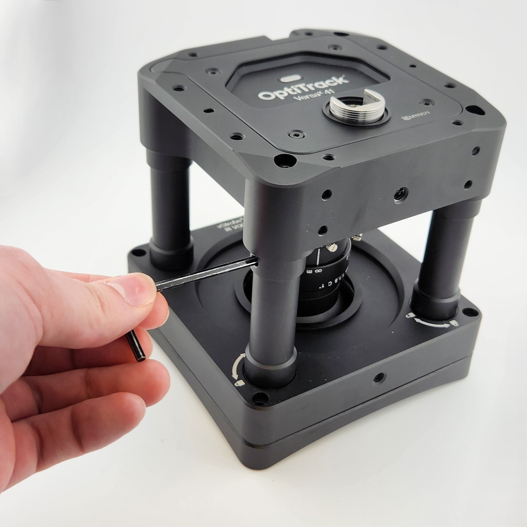 A photo of a hand inserting the locking tool into the locking mechanism on the VersaX ring light.